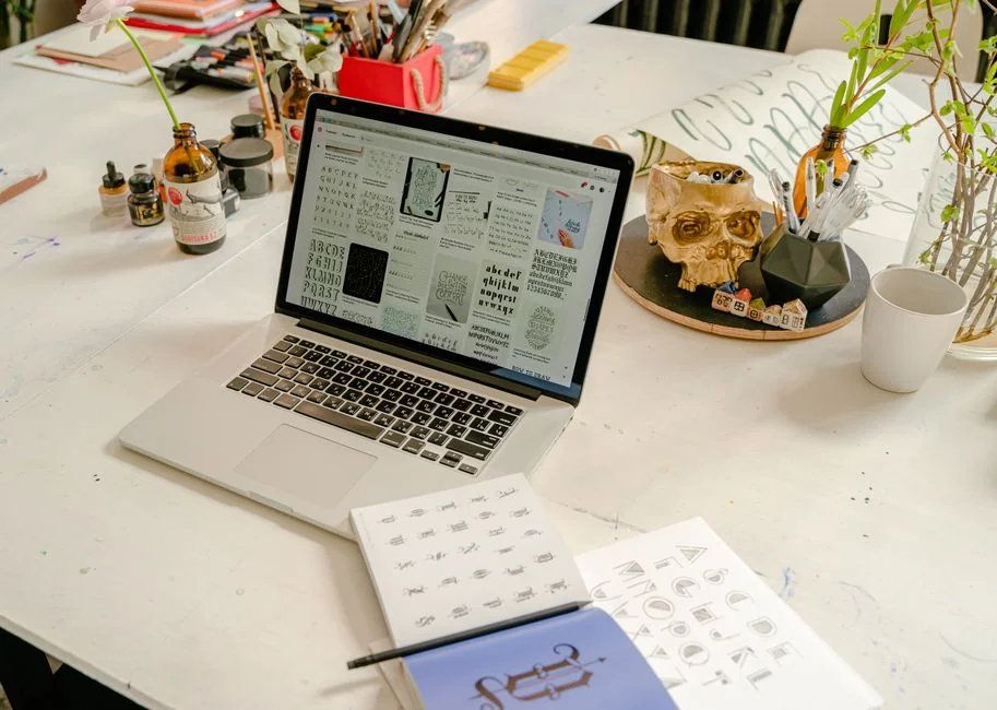 Gros plan sur un smartphone affichant une image floutée, posé sur un bureau à côté d’un ordinateur portable.