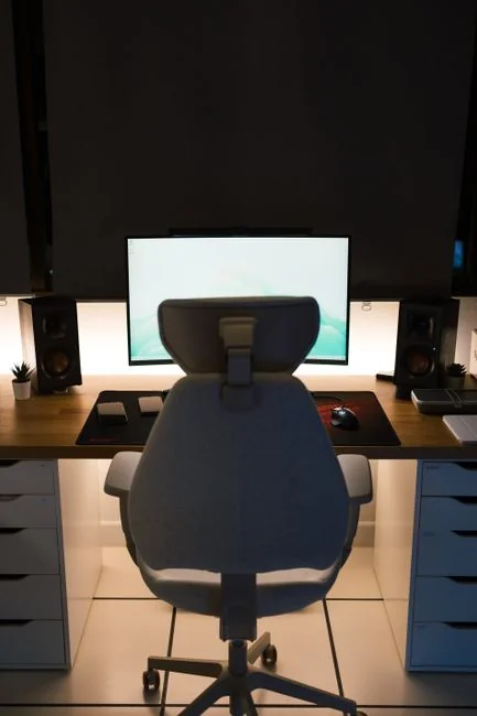 Vue d’en haut d’une personne sans visage consultant un téléphone mobile tout en travaillant à la maison sur une table en marbre blanc, avec des gadgets, un stylo et un crayon
